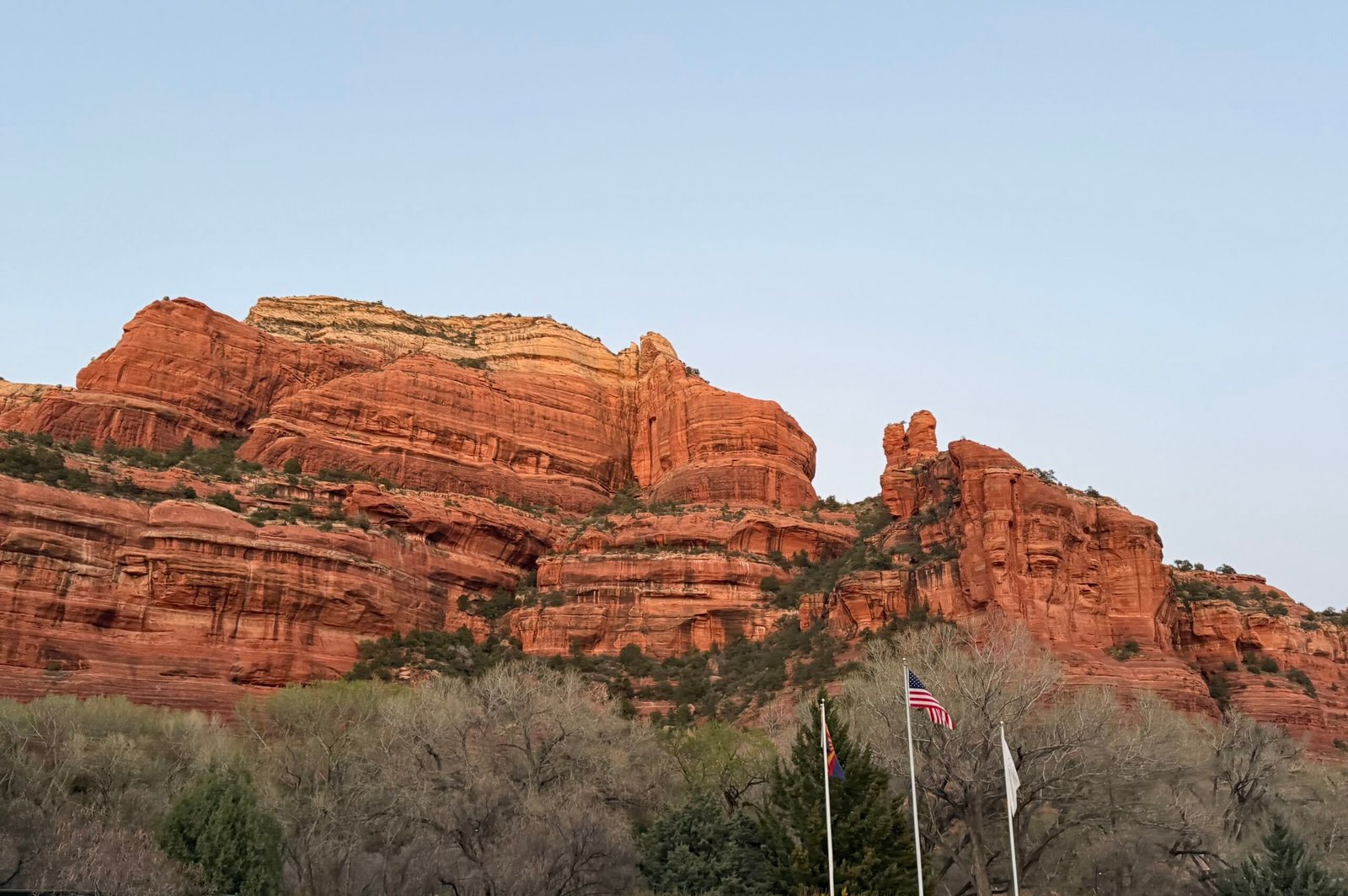 Red rock mesas in Sedona Arizona with US and state flags in the foreground